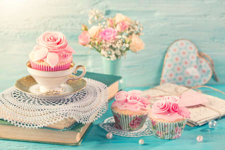Cupcakes with pink flowers. Retro vintage still life.の写真素材