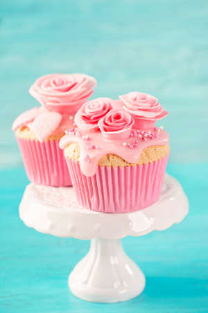 Cupcake with pink flowers on a blue wooden backgroundの写真素材
