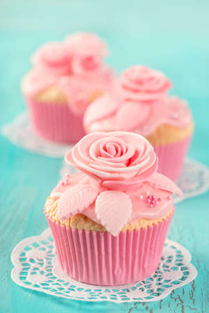 Cupcake with pink flowers on a blue wooden backgroundの写真素材