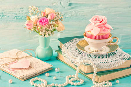 Cupcakes with pink flowers. Retro vintage still life.の写真素材