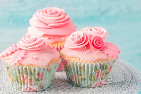 Cupcake with pink flowers on a blue wooden backgroundの写真素材