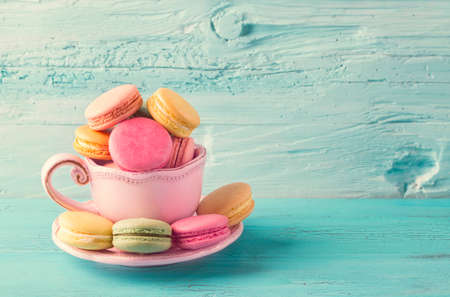 Colorful macarons in a cup on a blue wooden backgroundの写真素材