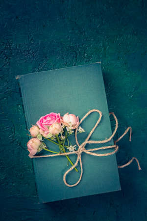 Pink flowers and the old book on a blue backgroundの写真素材