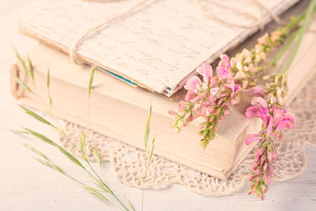 Old book and flowers on the tableの写真素材