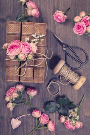 Pink flowers and the old books on a brown backgroundの写真素材