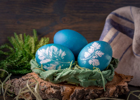 Natural dyed easter eggs on a wooden background. Colored with red cabbage. For greenish blue red cabbage with soda can be used.の写真素材