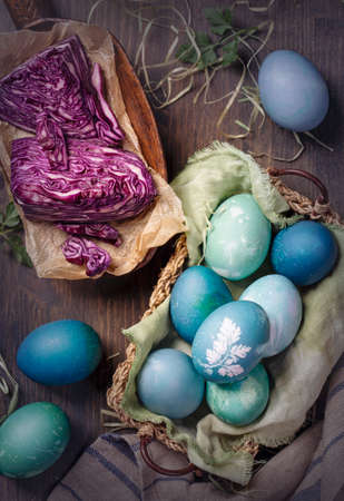 Natural dyed easter eggs on a wooden background. Colored with red cabbage. For greenish blue red cabbage with soda can be used.の写真素材