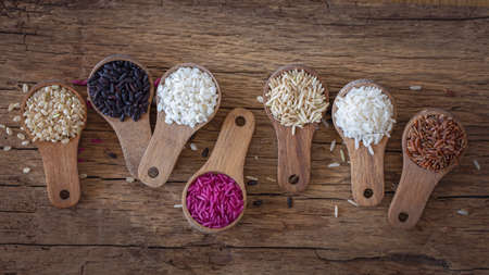 Different types of rice in wooden spoonsの写真素材