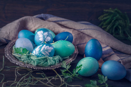 Natural dyed easter eggs on a wooden background. Colored with red cabbage. For greenish blue red cabbage with soda can be used.の写真素材