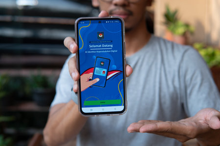 Jakarta, Indonesia - 15 December 2023 : Display of the digital State Population Identity (IKD) application. Indonesian Resident Identity Card replacement application, with a blurred backgroundのeditorial素材