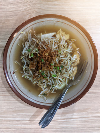 Lontong racing, a traditional Indonesian dish from Surabaya, East Java, consisting of bean sprouts, tofu, lontong, and sprinkled with crispy fried garlicの写真素材