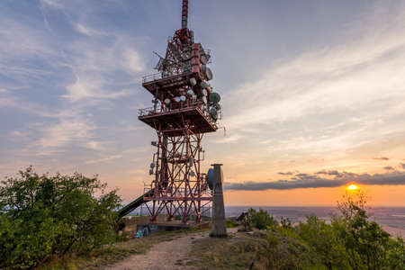 Transmitter tower antenna during the sunset on small hill.の写真素材