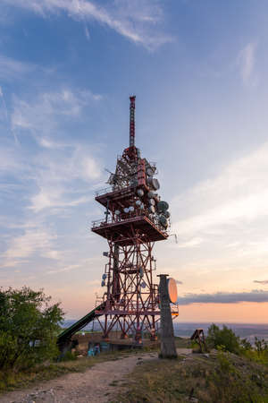 Transmitter tower antenna during the sunset on small hill.の写真素材