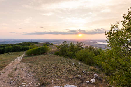 Sunset landscape panorama, hills in golden hour, small village in valley, beautiful colors and cloudsの写真素材