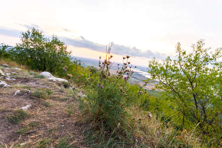 Sunset landscape panorama, hills in golden hour, small village in valley, beautiful colors and cloudsの写真素材