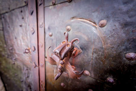 Big metal dragon handle placed on doors to castle.の写真素材