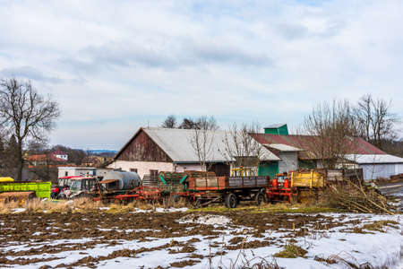 Old farm agriculture technology, metal machines and vehicles. Near the field and countryside land.の写真素材