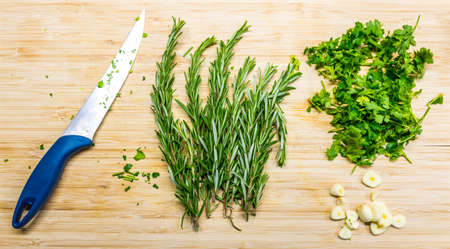 Thyme and parley placed on the wooden desk with knife. Fresh and healthy plants prepared for...