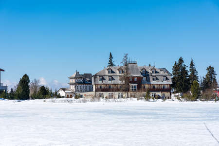 Slovakia: Strbske pleso resort, view of frozen lake in winter and hotel resort above. Blue skyの写真素材