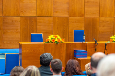 BRNO, CZECH REPUBLIC - 12.7.2019: Graduation ceremony at Masaryk University in Brno. The diploma certificate is prepared on the table. Families of the students are waiting in university auditoriumのeditorial素材