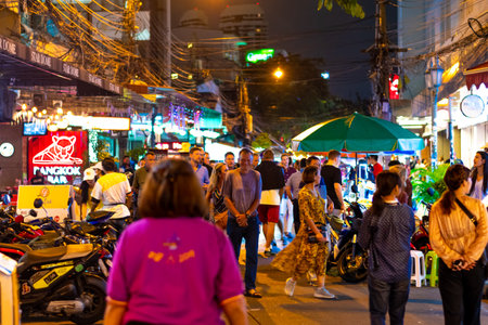 BANGKOK, THAILAND - 1.11.2019: Street market with street food, pubs and shops in Bangkok city. Night view of peoples walking on the road, shopping for food, chicken meal or fried insect.のeditorial素材