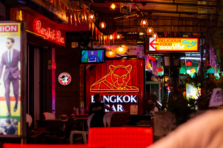 BANGKOK, THAILAND - 1.11.2019: Street market with street food, pubs and shops in Bangkok city. Night view of peoples walking on the road, shopping for food, chicken meal or fried insect.のeditorial素材