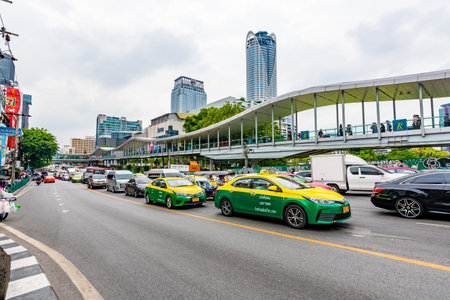 BANGKOK, THAILAND - 2.11.2019: Bangkok city street, view of traffic, cars, tuk tuks on the street. Peoples and tourist are walking on side. Skyscrapers in the background. Famous tourist destinationのeditorial素材