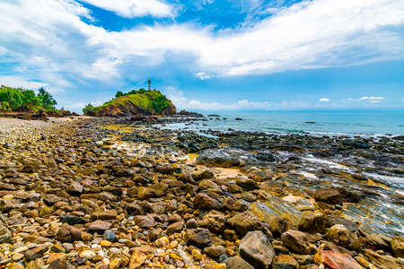 Lighthouse on the rock at Mu Ko Lanta national park, Thailand. View from the beach with stones....