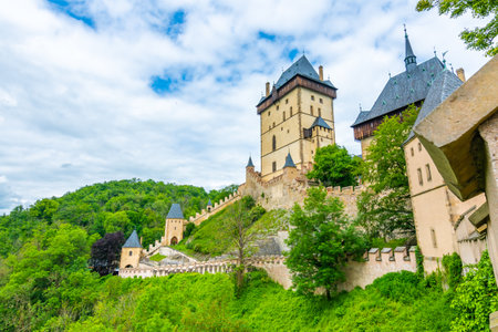 Famous medieval gothic castle Karlstejn on top of the hill. Beautiful stronghold is built by king Charles IV. Historical national heritage of Czech Republic is placed near Prague city. Cloudy weatherのeditorial素材