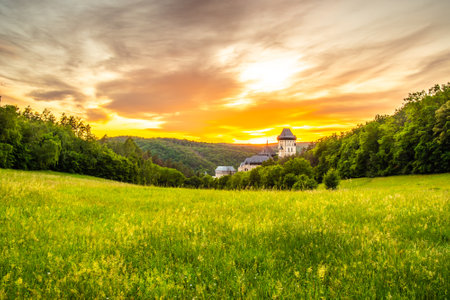 Beautiful sunset over famous Czech Republic castle, the Karlstejn. Medieval castle built in gothic style by king and emperor of old Roman rise, Charles IV. Dramatic sky, vibrant colors.のeditorial素材