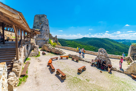 Cachtice, Slovakia - 4.7.2020: Tourists are visiting ruin of medieval castle Cachtice. Famous castle known from legend about blood lady Bathory. Summer weather, blue sky.のeditorial素材