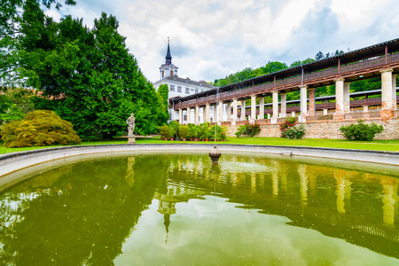 Lysice castle, Czech Republic. Famous baroque castle built in 14th century. Beautiful formal garden, palm trees and flowers. Promenade near the castle. Sunny day, dramatic clouds before storm.のeditorial素材