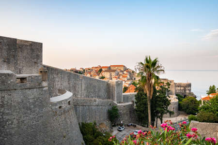 Panoramic view of sunrise over old town of Dubrovnik. Ancient city wall and Minceta tower. Famous tourist destination in Croatia. Summer morning, soft warm light.  .の写真素材