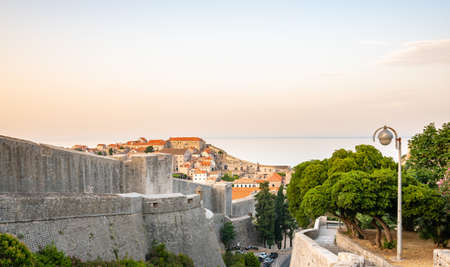 Panoramic view of sunrise over old town of Dubrovnik. Ancient city wall and Minceta tower. Famous tourist destination in Croatia. Summer morning, soft warm light.  .の写真素材