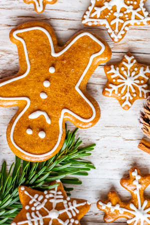 Christmas gingerbread and sweets are placed on a wooden desk. Cookies and sweet food in the shape of...