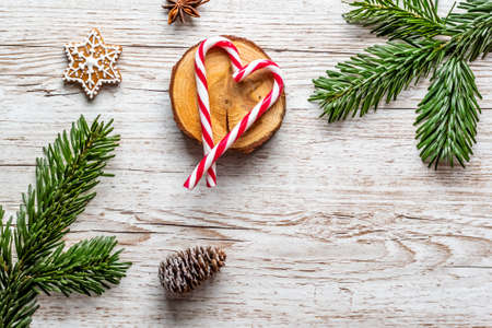 Candy cane christmas sweet red and white striped food in shape of heart. Placed on wooden desk. Winter and christmas theme.の写真素材
