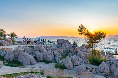 Makarska, Croatia - 22.7.2021: Peoples are looking to sunset at Makarska coast.のeditorial素材