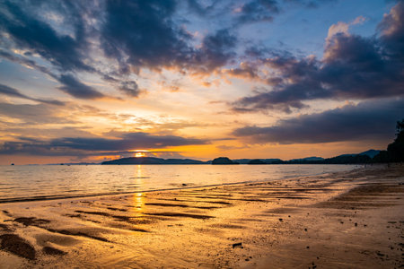 Beautiful sunset with dramatic clouds and sky of blue and orange color. Ao Nang beach, Krabi town, Thailand.の写真素材