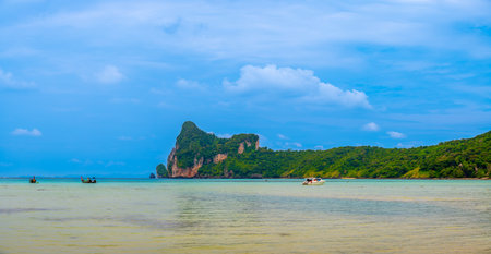Landscape view of coastline with limestone rock and boats on ocean at Ko Phi Phi islands, Thailand. Concept of exotic tropical vacation and beautiful nature in paradiseの写真素材