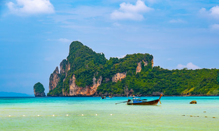 Landscape view of coastline with limestone rock and boats on ocean at Ko Phi Phi islands, Thailand. Concept of exotic tropical vacation and beautiful nature in paradiseの写真素材