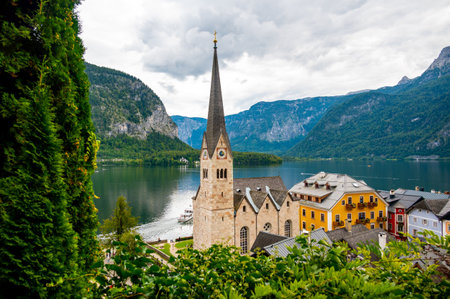 Famous Hallstatt city panorama with typical church near the Hallstatter see. Dramatic clouds on the sky. Famous tourist destination in Austria.の写真素材