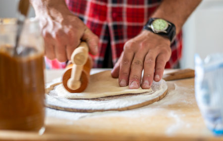 Detail of hands of men rolling the dough. Preparation for baking of traditional Czech pastry....
