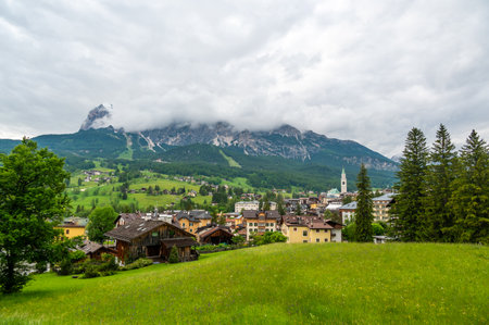 A panoramic view of the picturesque town of Cortina d'Ampezzo, nestled in the heart of the Dolomites. Majestic mountains rise in the background, offering a stunning natural backdrop.の写真素材