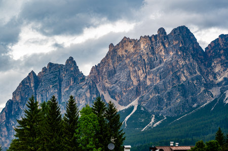 A panoramic view of the picturesque town of Cortina d'Ampezzo, nestled in the heart of the Dolomites. Majestic mountains rise in the background, offering a stunning natural backdrop.の写真素材