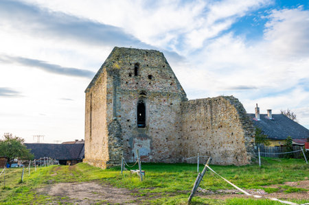 A photo of the ruins of the Koruna Svate Marie Monastery near the village of Trebarov. The ancient stone walls and arches stand as a testament to history, surrounded by greenery. This historic site evokes a sense of mystery and timelessness within the Czech landscapeの写真素材