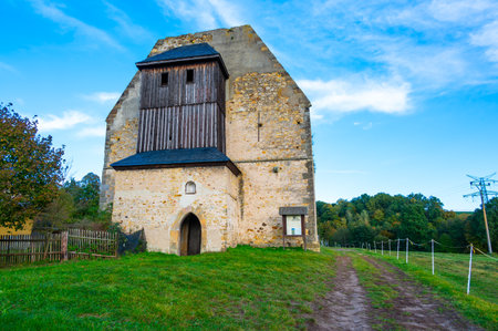A photo of the ruins of the Koruna Svate Marie Monastery near the village of Trebarov. The ancient stone walls and arches stand as a testament to history, surrounded by greenery. This historic site evokes a sense of mystery and timelessness within the Czech landscapeの写真素材