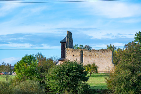 A photo of the ruins of the Koruna Svate Marie Monastery near the village of Trebarov. The ancient stone walls and arches stand as a testament to history, surrounded by greenery. This historic site evokes a sense of mystery and timelessness within the Czech landscapeの写真素材