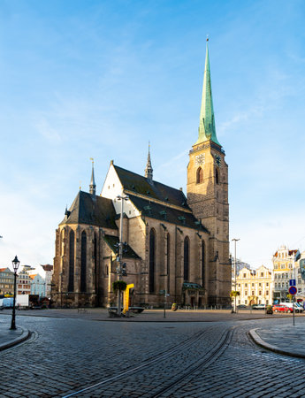A photograph of the Cathedral of St. Bartholomew in Plzen, Czech Republic. This Gothic cathedral with its iconic tower stands proudly, surrounded by historic buildings, offering a stunning viewの写真素材