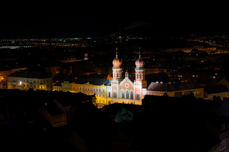 A captivating night view of the illuminated synagogue in Pilsen, showcasing its stunning architecture and warm lights, creating a serene and magical atmosphereの写真素材