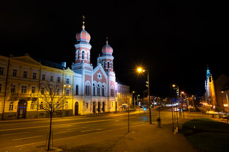 A captivating night view of the illuminated synagogue in Pilsen, showcasing its stunning architecture and warm lights, creating a serene and magical atmosphereの写真素材
